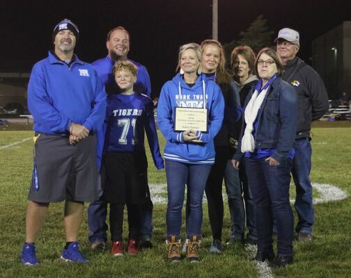Adria Palmer, high school counselor at Mark Twain High School, was surprised with an award for Northeast Missouri Secondary Counselor of the Year at halftime during the Homecoming game. Pictured are MTHS principal Deacon Windsor, Palmer’s husband, Ritchie Palmer, her children, Greyson and Adalynn, her parents, Tona &amp; Hurley Brown, and elementary counselor Diana Duckworth who nominated Palmer and presented the award.