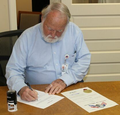 Signing paperwork after being sworn in is Robert Van Winkle.